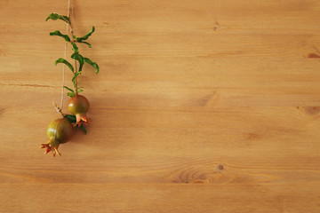Rosh hashanah (jewesh New Year holiday) concept - pomegranate over wooden background. Traditional symbol