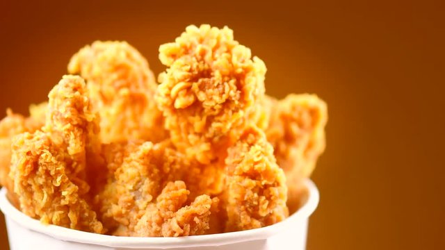 Fried chicken wings and legs. Bucket full of crispy kentucky fried chicken. Rotation 360 degrees. 4K UHD video footage. Ultra high definition 3840X2160