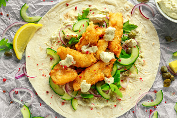 Fresh Fish Tortilla with cucumber, red onion, Capers, lemon, salad leaves and tartare sauce. Healthy Food