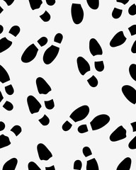 Fototapeta na wymiar Seamless pattern of black silhouettes of prints of shoes