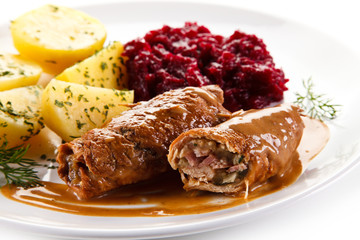 Wrapped pork chops with potatoes and beetroots on white background