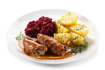 Wrapped pork chops with potatoes and beetroots on white background