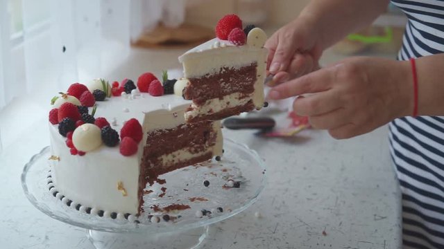 The woman puts the cake in the dish to children