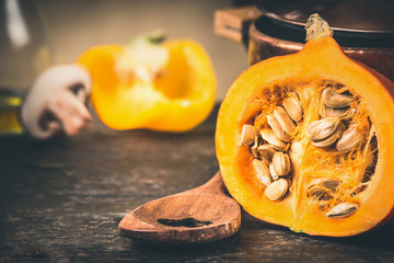 Half pumpkin with seeds and cooking spoon, front view, close up