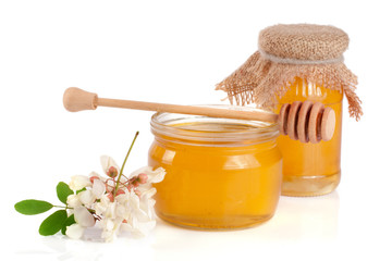Jar of honey with flowers of acacia isolated on white background