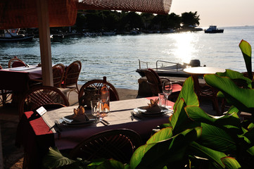 Nakryte stoliki restauracji w blasku zachodzącego słońca.