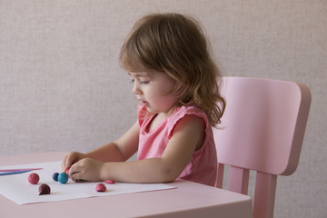 Little girl play with plasticine at home