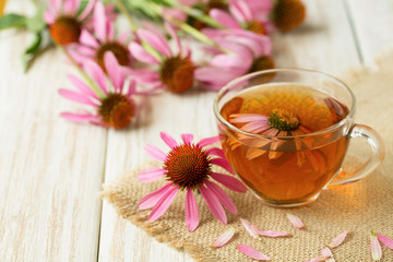 Cup of echinacea tea on white wooden table