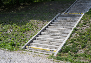 Staircase made of concrete. Green grass is around stairway