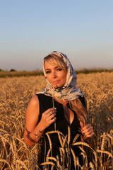 Молодая девушка с платком на пшеничном поле
