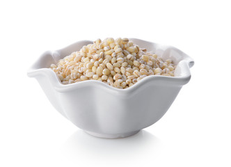 Heap of pearl barley in a bowl on white background