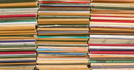 A stack of old school notebooks. Multicolored cover.