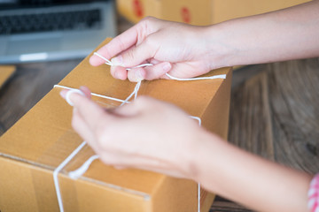 business owner packing cardboard box at workplace. freelance woman seller prepare parcel box of product for deliver to customer.  Online selling, internet marketing, e-commerce, shipping concept