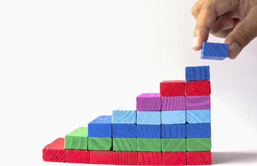 Make success,Concept of building success foundation. Hand put red puzzle wooden blocks in the shape...