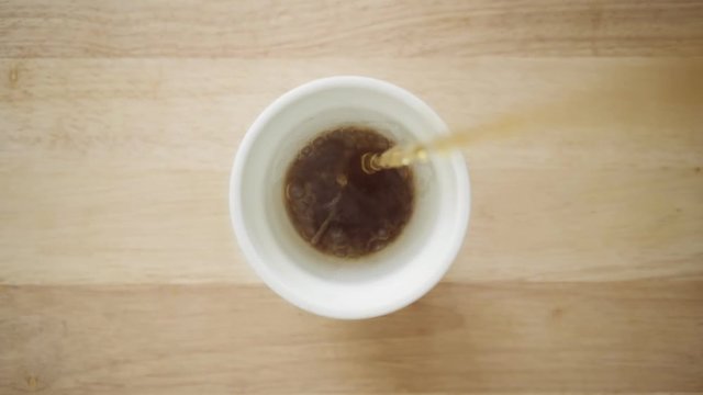 Top view close up static clean shot of pouring down black american shitty coffee for breakfast, cheap espresso with water refill, inside diner or restaurant