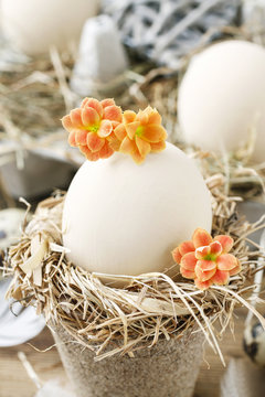 Simple easter decoration with egg, hay wreath and Kalanchoe blossfeldiana flowers.