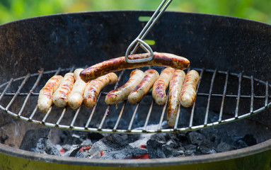 Würste werden auf einem Grill zubereitet