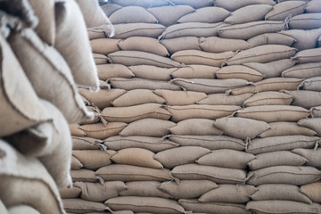 hemp sacks containing coffee bean in warehouse. stacked sacks in storehouse.