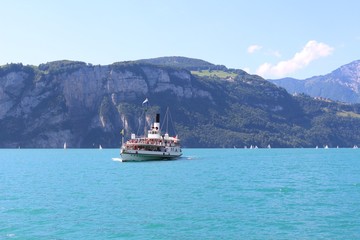 Paddle wheel ship and sailing boats in the distance at Lake Lucerne, Sisikon, Switzerland