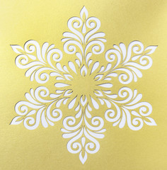 White snowflake shape on golden background.