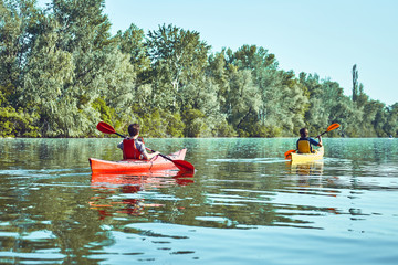 A canoe trip along the river along the forest in summer.