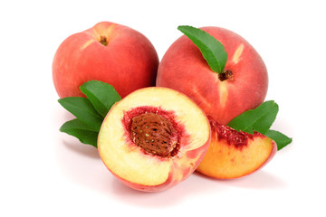 Peaches and half with green leaf isolated on white background