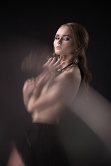 Fototapeta premium Portrait of a nude, stylish, beautiful girl, model with a beautiful glow in the studio. Nude, potret, studio, style, beauty.