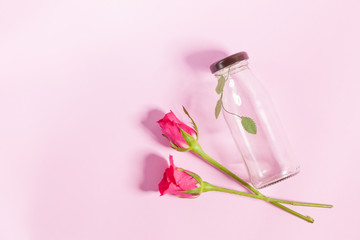 Empty bottle and rose On the pink background 