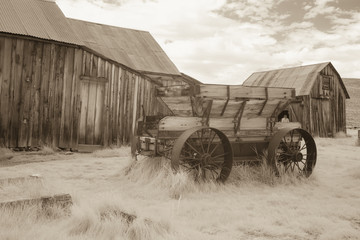 Fototapeta na wymiar Wooden cart and barns in Bodie, California in black and white