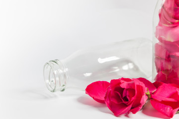 Empty bottles and rose petals On the white background 