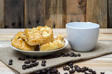 Morning breakfast coffe cup and pink rose on wooden table