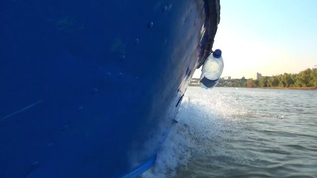The hull of the blue boat on the left side, the movement along the river in good weather without large waves