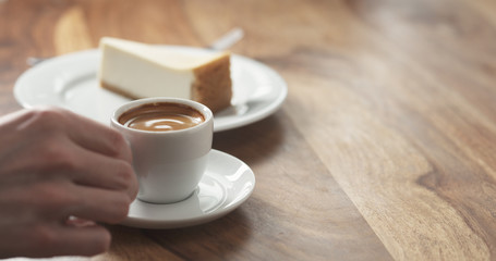 man hand eating cheesecake and drink coffee
