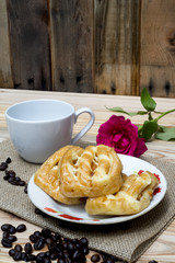 Morning breakfast coffe cup and pink rose on wooden table