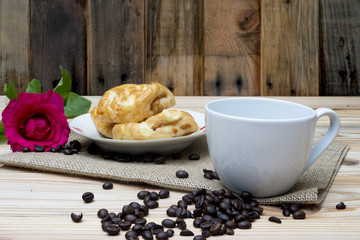 Morning breakfast coffe cup and pink rose on wooden table