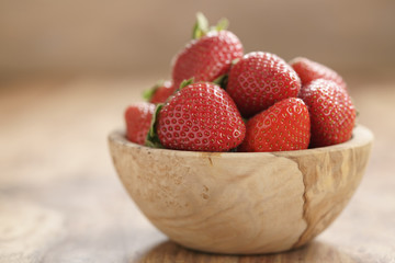fresh strawberries in bowl on wood table