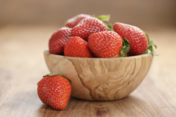 fresh strawberries in bowl on wood table