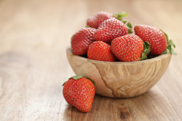 fresh strawberries in bowl on wood table