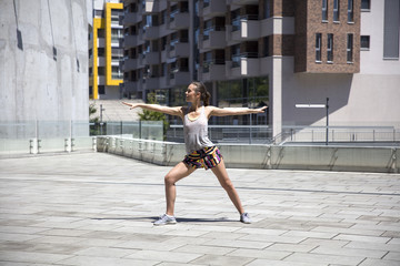 Attractive woman exercise stretching in urban environment at sunny day