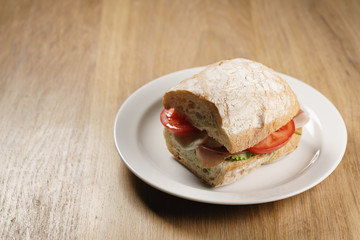 ciabatta sandwich with speck, mozzarella and vegetables