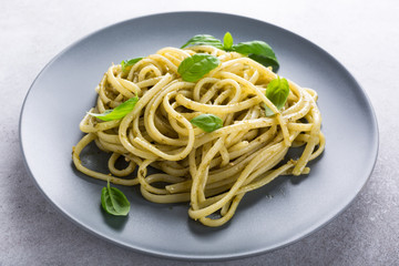 Homemade pasta, spaghetti, linguine with green pesto and basil. Italian healthy food concept.