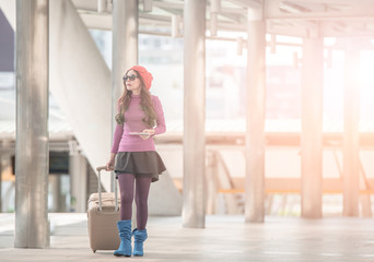 Naklejka premium woman traveler walking with suitcase at airport corridor