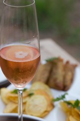 Glass of sparking wine. Food in the background is in soft focus. Shot in the Selous game reserve, Tanzania