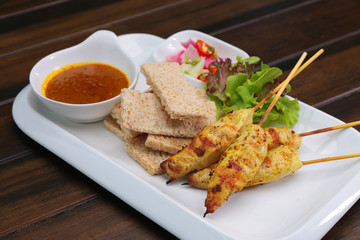 Chicken Satay served with Peanut Sauce and bread , Asian skewers famous food