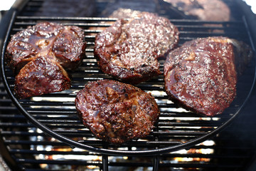 Closeup of a beef steak on the grill. Shallow depth of field