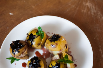 Baked apples with cottage cheese, chocolate, nuts, mint. Apples on a white plate