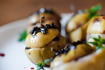 Baked apples with cottage cheese, chocolate, nuts, mint. Apples on a white plate