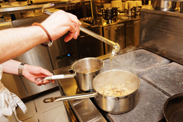 Chef is pouring broth in pot, toned