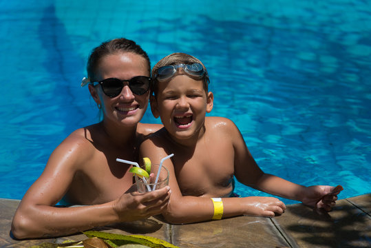 Mom and son rest together in the pool on a warm, summer day. Childhood, summer, swimming, swimming pool, family values.