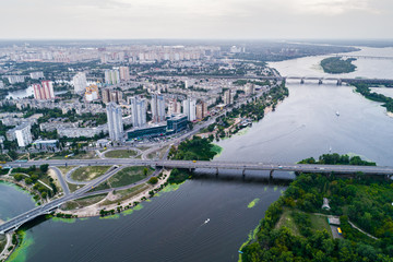 Obraz premium Residential district in a large metropolis with road junctions and houses near Dnepr river in Kiev, Ukraine. Aerial view. From above.